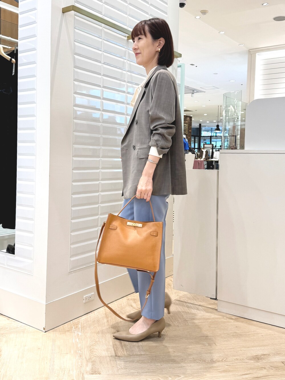 ブルー系のその他パンツ、イエロー系のショルダーバッグ、ブラウン系のテーラードジャケットを着用したレディースの秋コーディネートの7枚目の写真