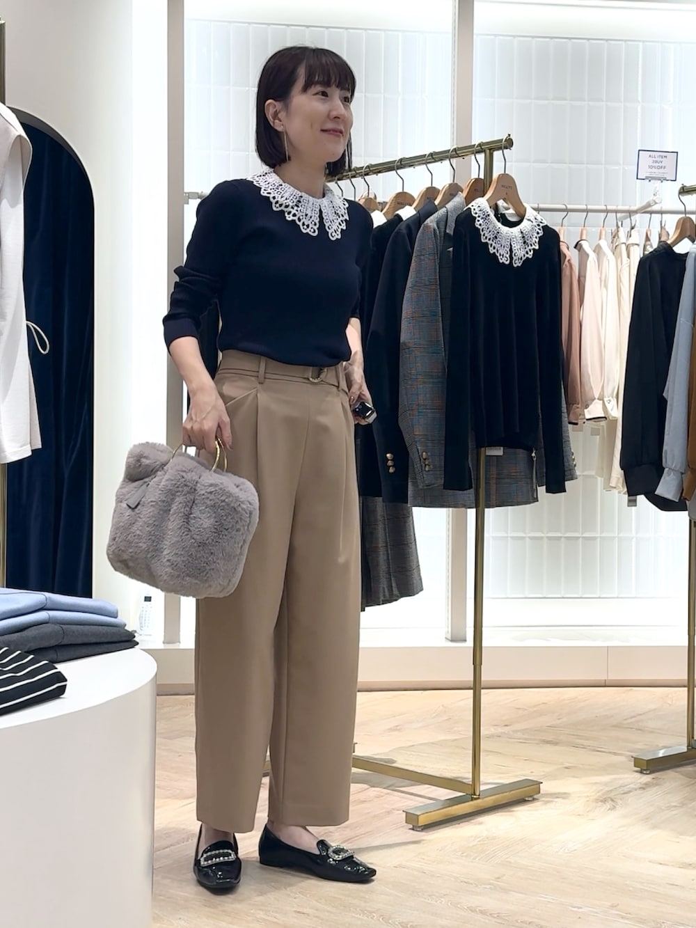 ベージュ系のその他パンツ、グレー系のショルダーバッグ、ブルー系のニット/セーターを着用したレディースの秋コーディネートの9枚目の写真