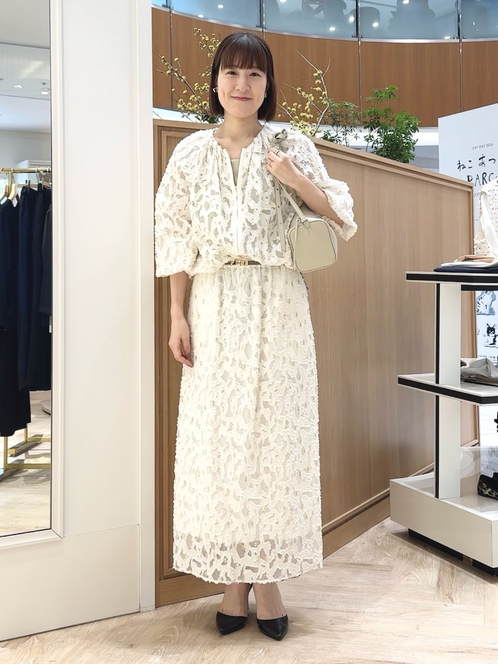 ホワイト系のショルダーバッグ、ゴールド系のタンクトップ、ホワイト系のブルゾンを着用したレディースの冬コーディネートの2枚目の写真