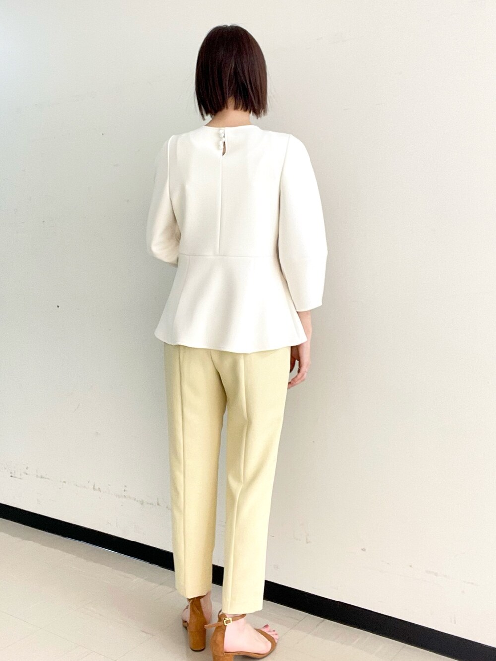 イエロー系のその他パンツ、ホワイト系のTシャツ/カットソー、ゴールド系のイヤーカフを着用したレディースの冬コーディネートの4枚目の写真