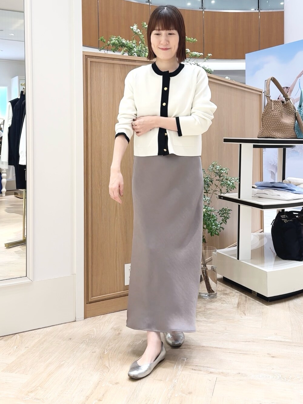 ベージュ系のトートバッグ、ホワイト系のシャツ/ブラウス、グリーン系のスカートを着用したレディースの春コーディネートの8枚目の写真