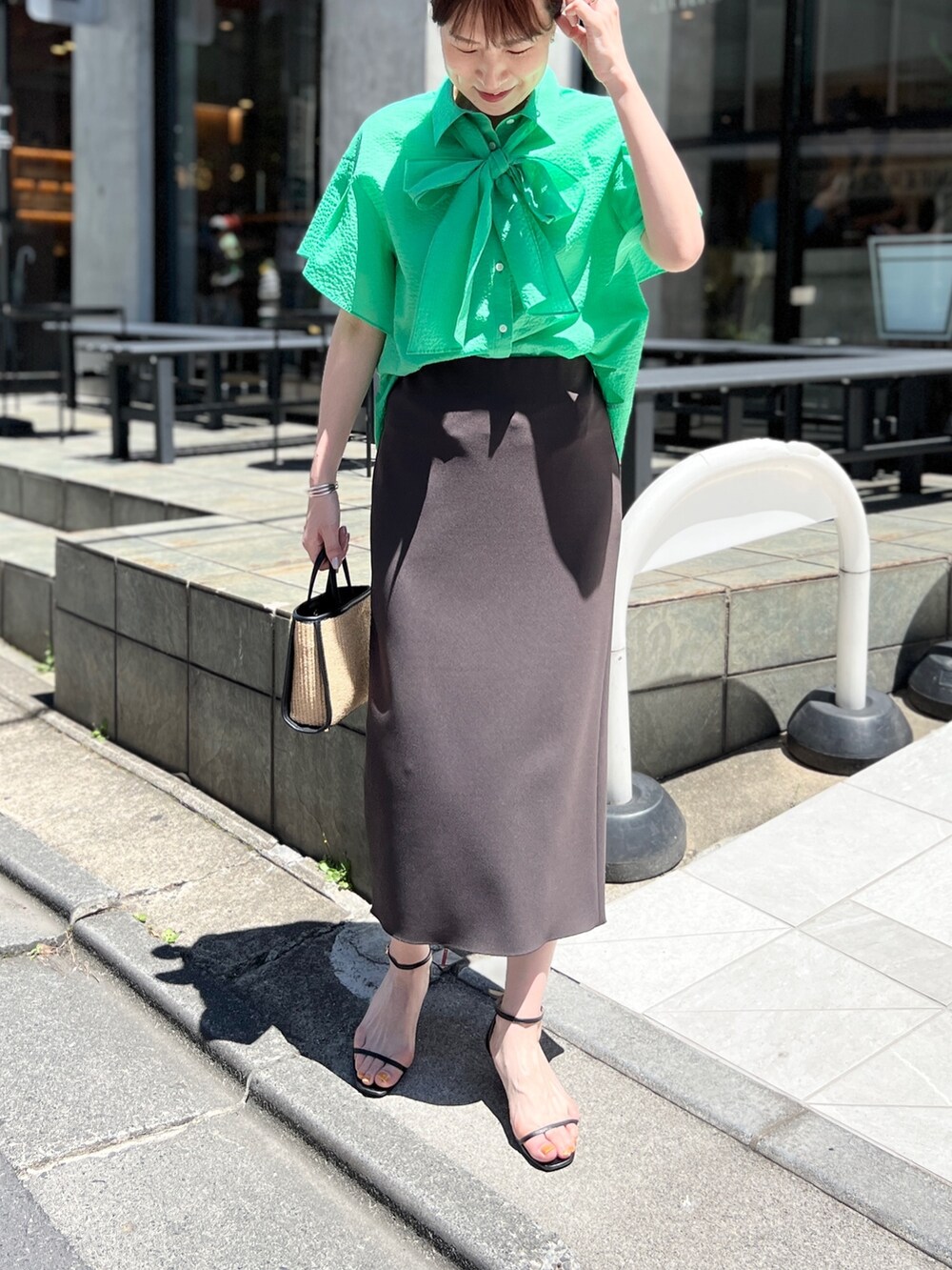 ブラック系のトートバッグ、グレー系のスカート、ブラック系のサンダルを着用したレディースの夏コーディネートの3枚目の写真