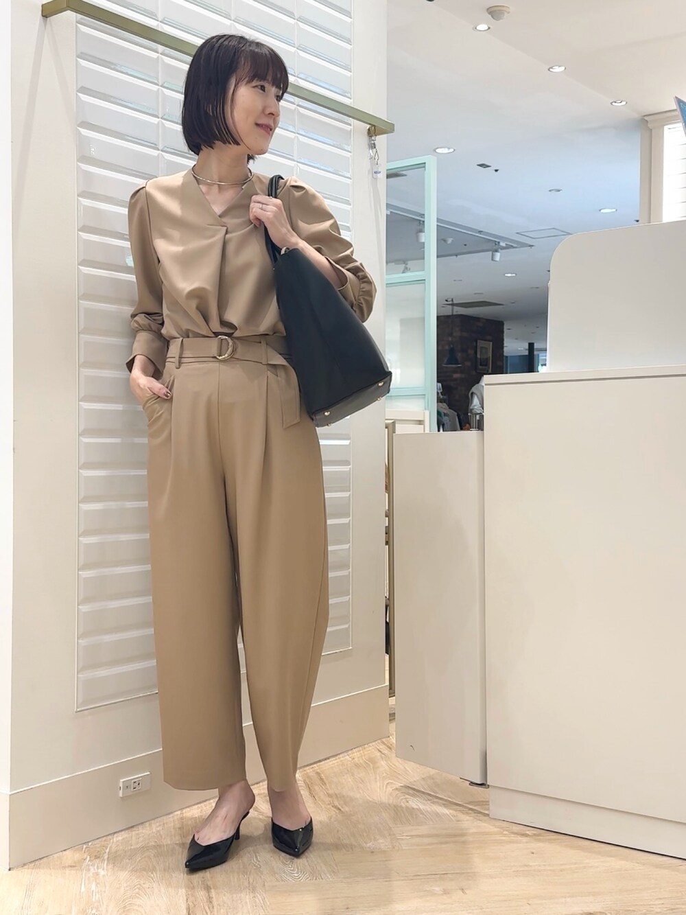 ブラック系のショルダーバッグ、ベージュ系のその他パンツ、ベージュ系のシャツ/ブラウスを着用したレディースの秋コーディネートの8枚目の写真