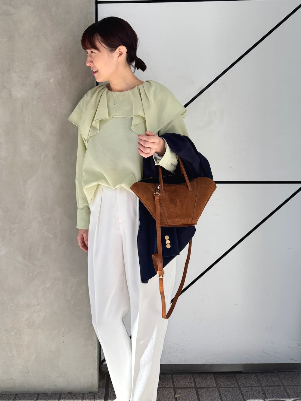 ホワイト系のその他パンツ、ブルー系のテーラードジャケット、イエロー系のトートバッグを着用したレディースの春コーディネートの6枚目の写真