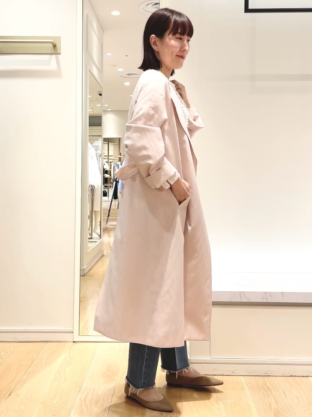 ベージュ系のニット/セーター、ピンク系のノーカラーコート、ホワイト系のシャツ/ブラウスを着用したレディースの春コーディネートの4枚目の写真