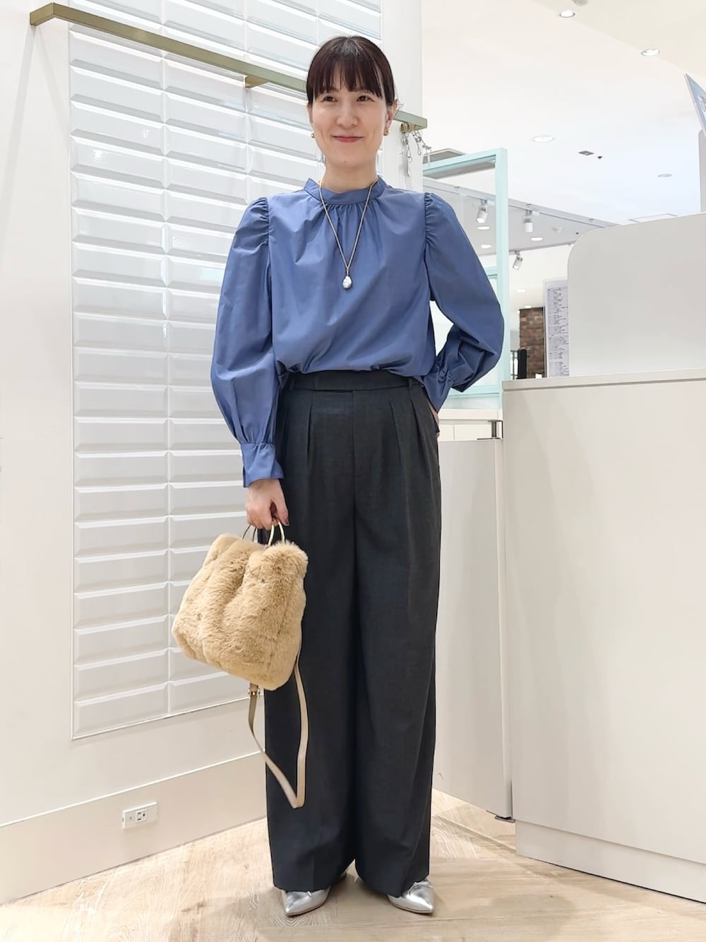 ブルー系のシャツ/ブラウス、ベージュ系のショルダーバッグ、グレー系のその他パンツを着用したレディースの秋コーディネートの2枚目の写真