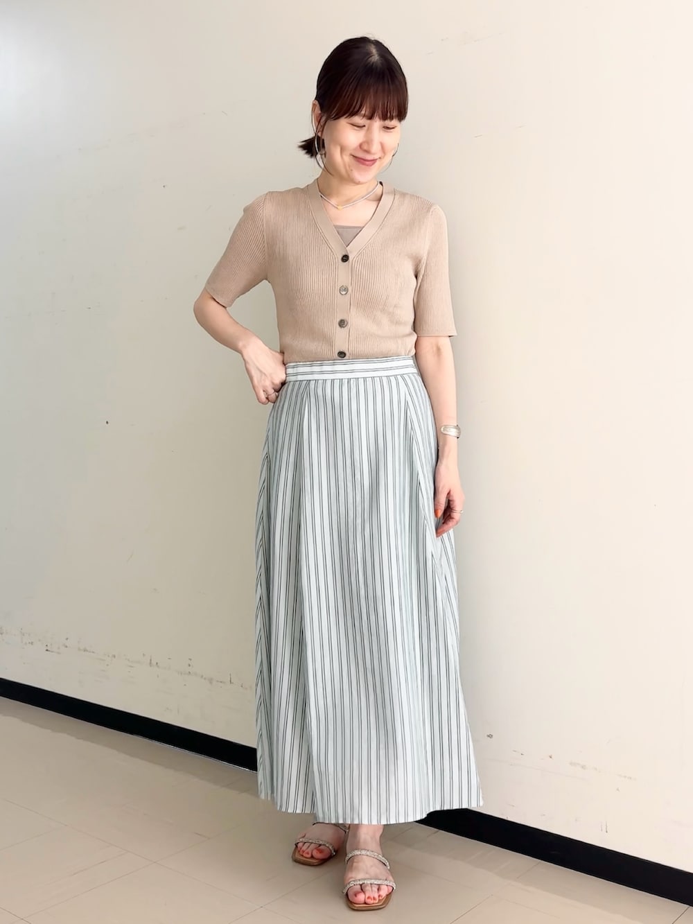 ブルー系のスカート、ベージュ系のカーディガン/ボレロ、ベージュ系のタンクトップを着用したレディースの夏コーディネートの8枚目の写真