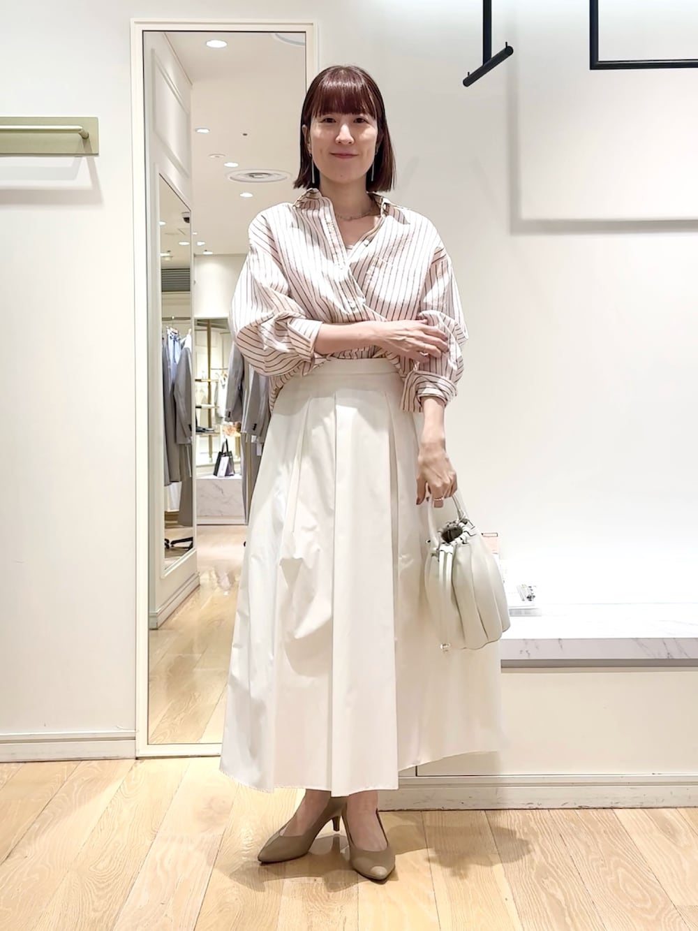 ホワイト系のスカート、ピンク系のシャツ/ブラウス、グレー系のネックレスを着用したレディースの春コーディネートの5枚目の写真