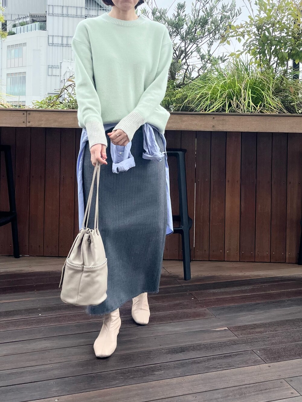 ベージュ系のトートバッグ、グレー系のスカート、グリーン系のニット/セーターを着用したレディースの冬コーディネートの3枚目の写真