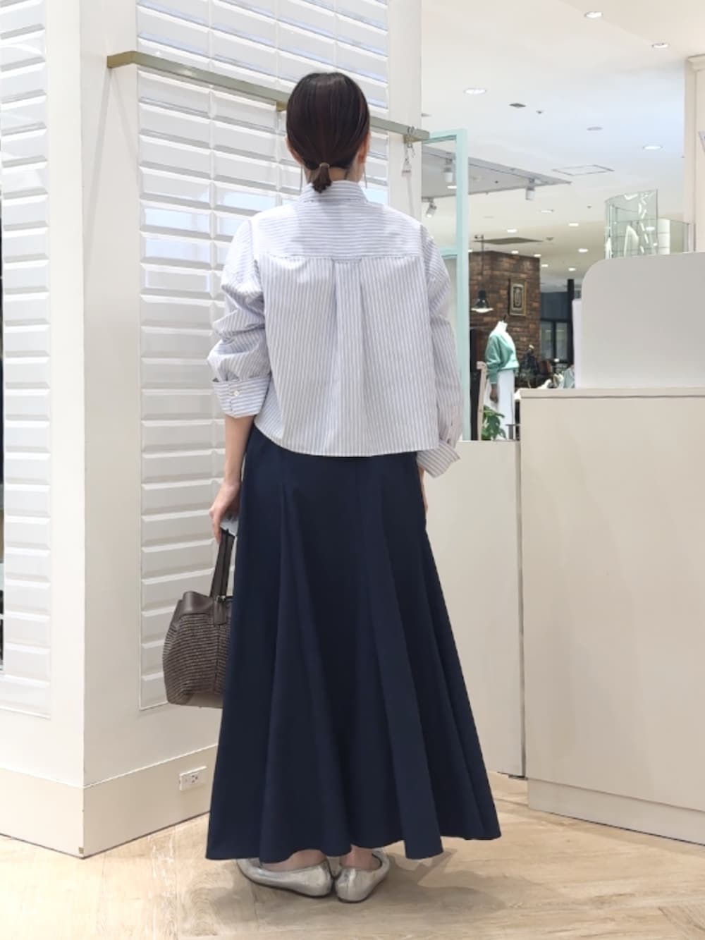 ブルー系のシャツ/ブラウス、ブルー系のスカート、ブラウン系のショルダーバッグを着用したレディースの春コーディネートの4枚目の写真