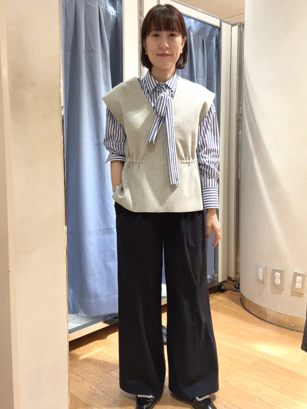 グレー系のベスト、ベージュ系のベストを着用したレディースの秋コーディネートの3枚目の写真