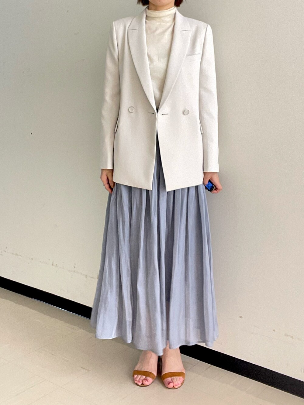 ホワイト系のニット/セーター、ベージュ系のテーラードジャケット、ゴールド系のイヤリングを着用したレディースの冬コーディネートの6枚目の写真