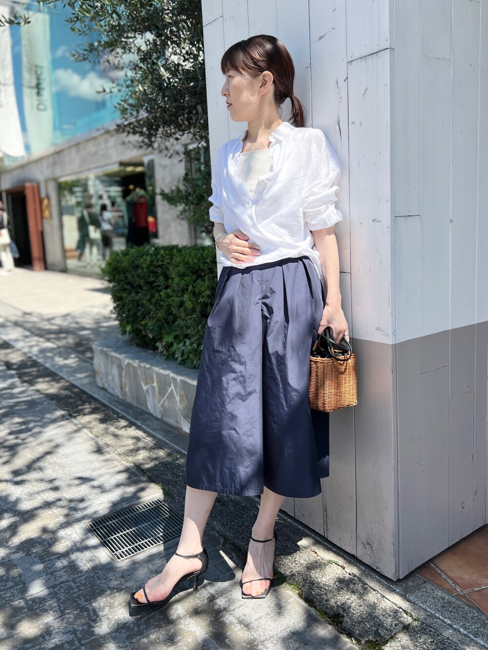 イエロー系のかごバッグ、ブルー系のその他パンツ、ホワイト系のシャツ/ブラウスを着用したレディースの夏コーディネートの6枚目の写真