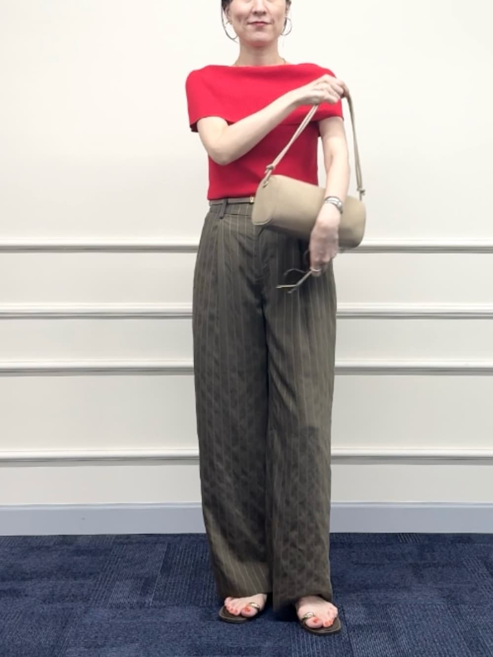 レッド系のニット/セーター、グリーン系のその他パンツ、ベージュ系のショルダーバッグを着用したレディースの夏コーディネートの7枚目の写真