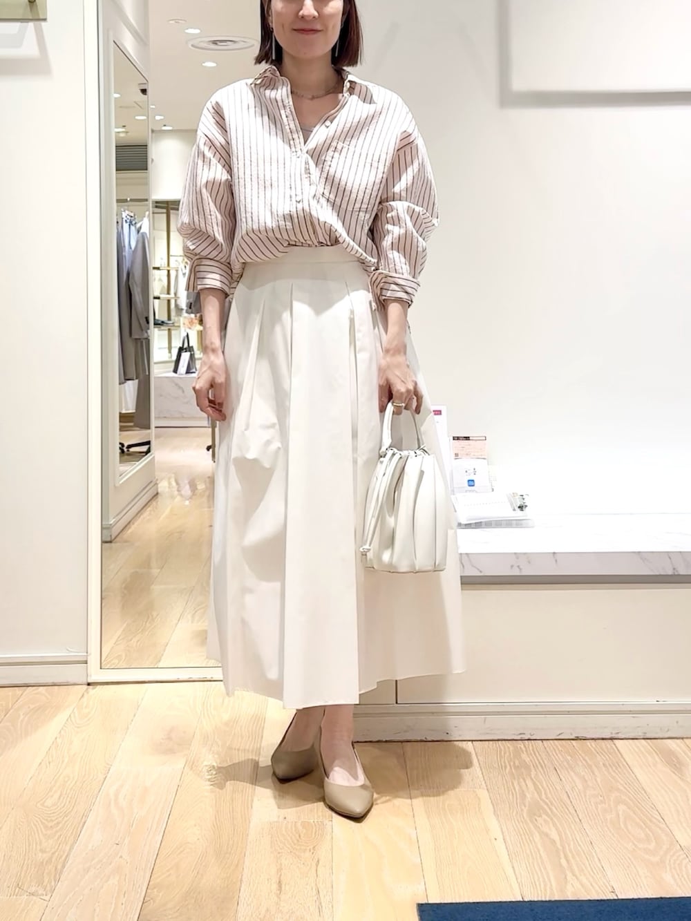 ホワイト系のスカート、ピンク系のシャツ/ブラウス、グレー系のネックレスを着用したレディースの春コーディネートの7枚目の写真