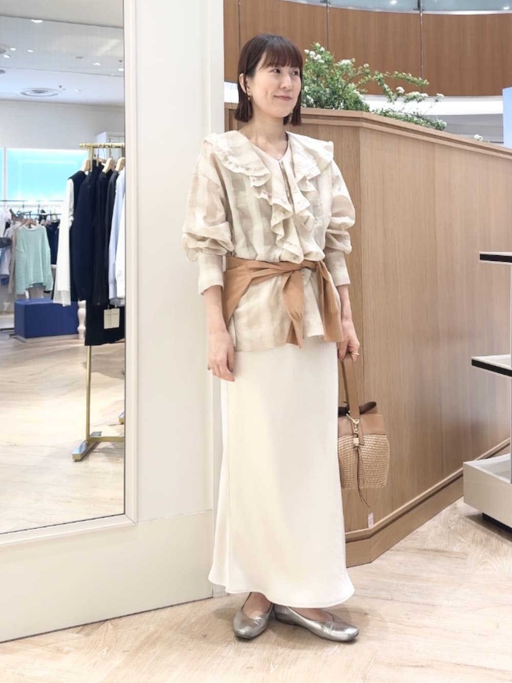 イエロー系のカーディガン/ボレロ、ホワイト系のシャツ/ブラウス、ベージュ系のショルダーバッグを着用したレディースの春コーディネートの2枚目の写真