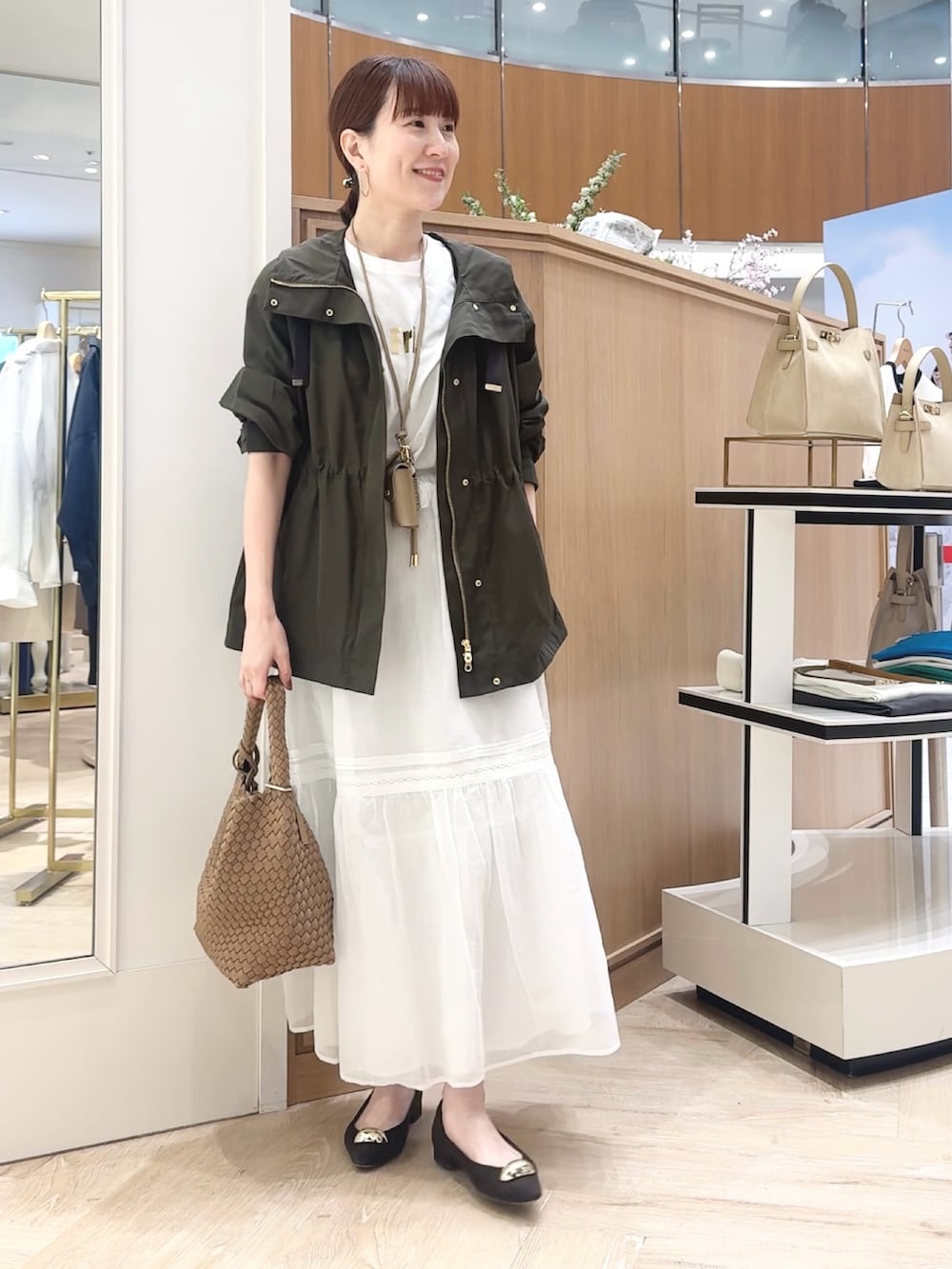 ブラウン系のショルダーバッグ、グレー系のブルゾン、ホワイト系のTシャツ/カットソーを着用したレディースの春コーディネートの9枚目の写真