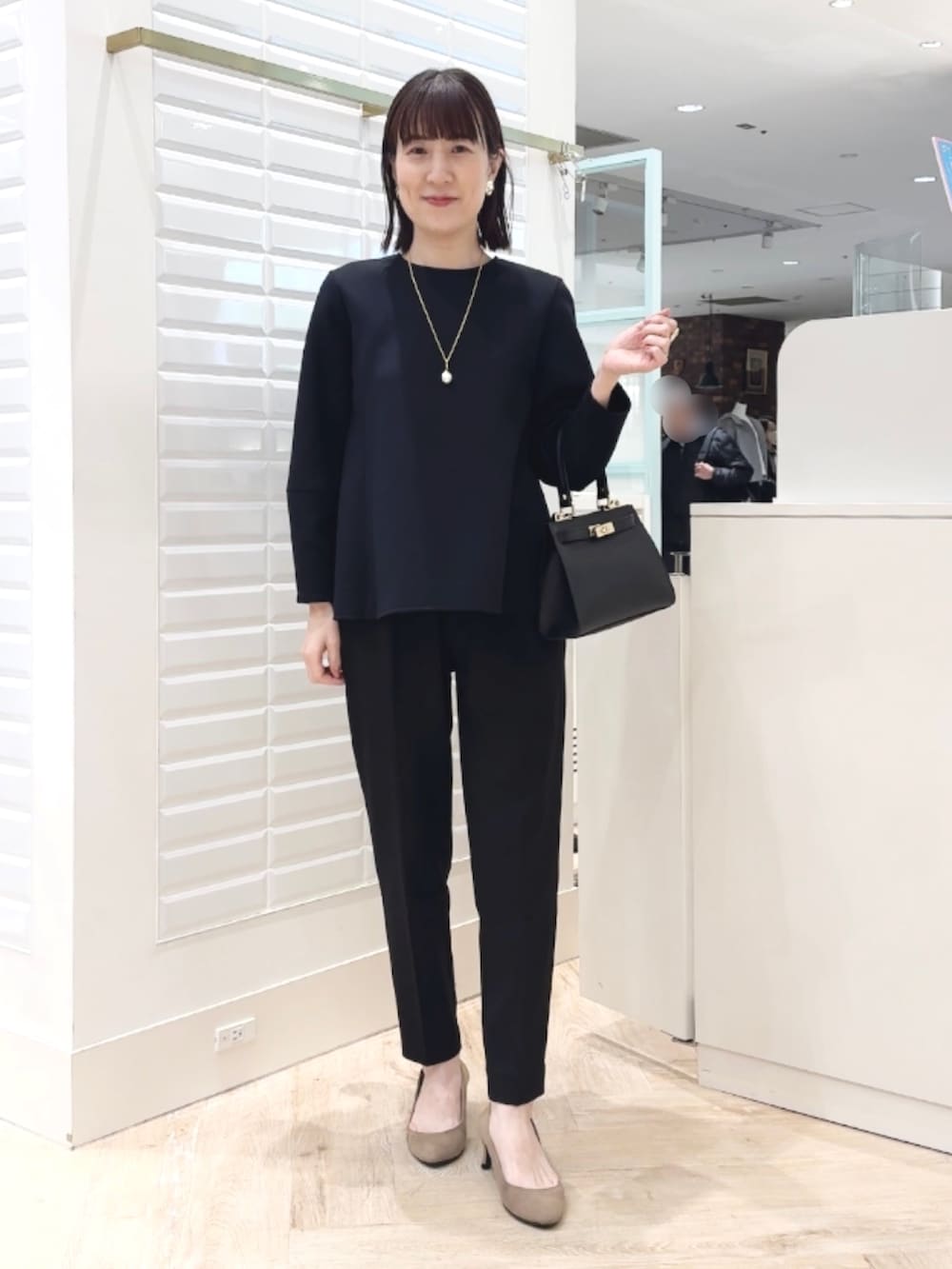 ブラック系のショルダーバッグ、ブラック系のその他パンツ、ブラック系のTシャツ/カットソーを着用したレディースの冬コーディネートの6枚目の写真