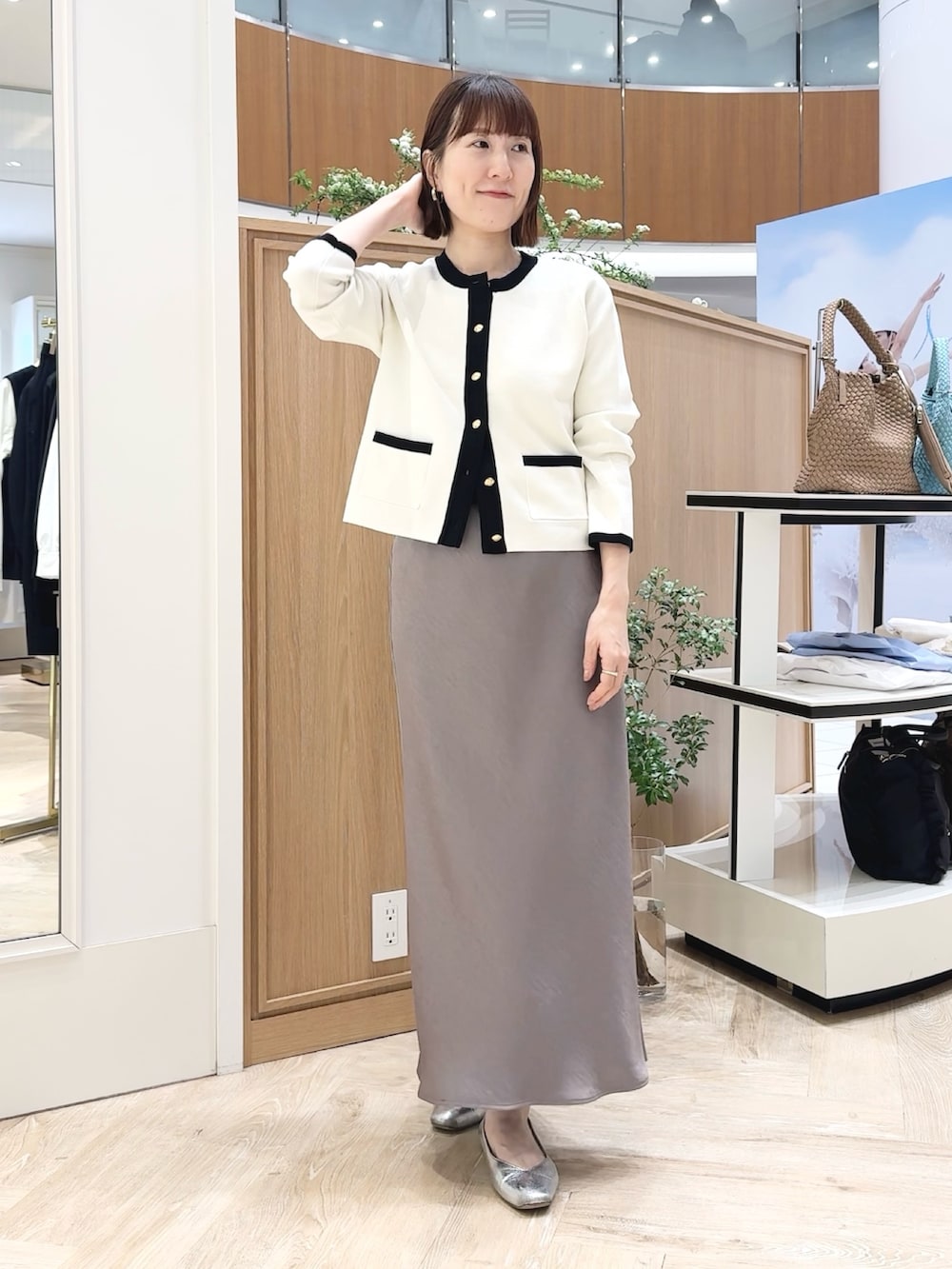 ベージュ系のトートバッグ、ホワイト系のシャツ/ブラウス、グリーン系のスカートを着用したレディースの春コーディネートの3枚目の写真