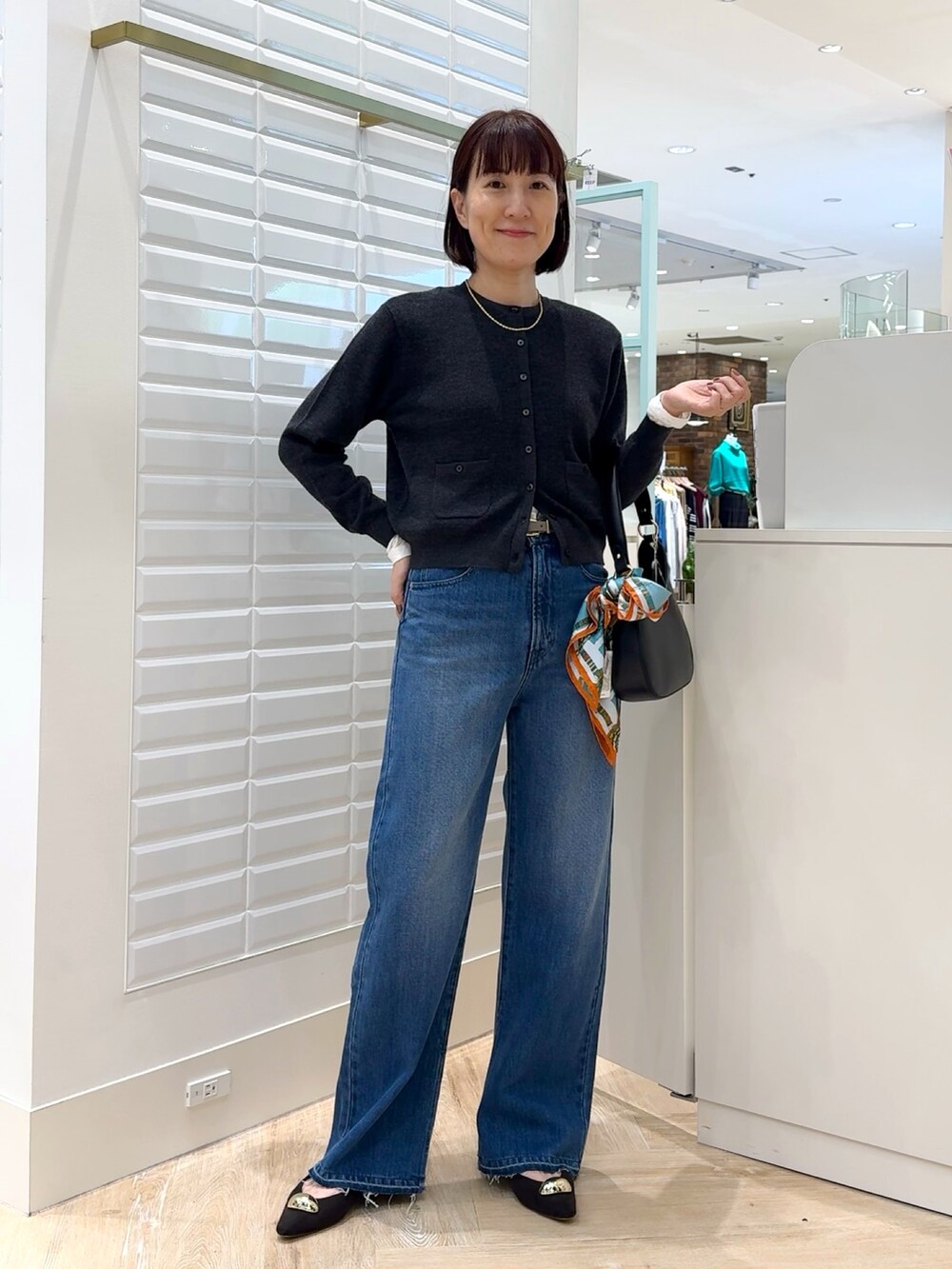 ブルー系のデニムパンツ、グレー系のカーディガン/ボレロ、ホワイト系のTシャツ/カットソーを着用したレディースの秋コーディネートの7枚目の写真