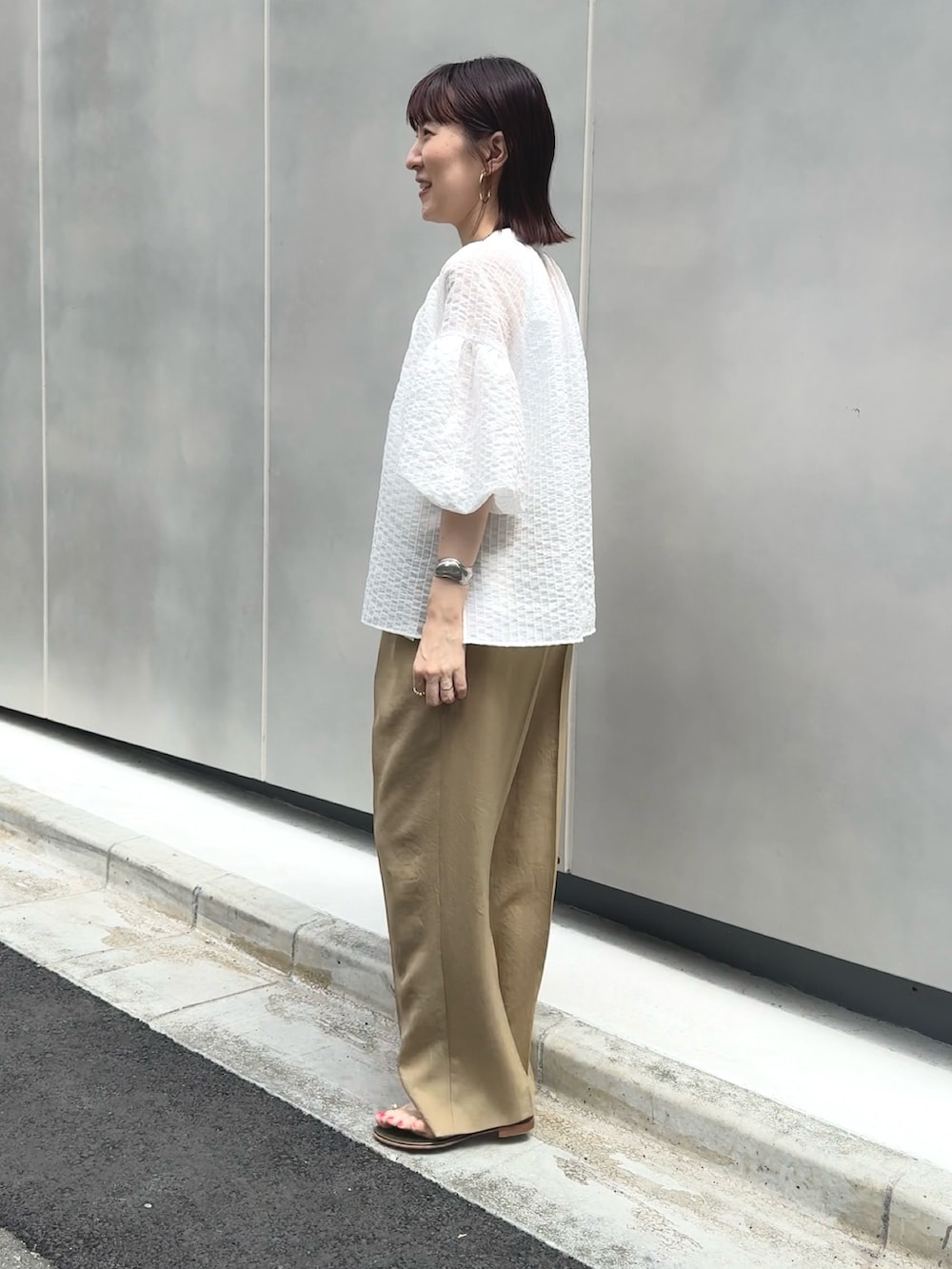 イエロー系のその他パンツ、ホワイト系のタンクトップ、ブラウン系のショルダーバッグを着用したレディースの夏コーディネートの5枚目の写真