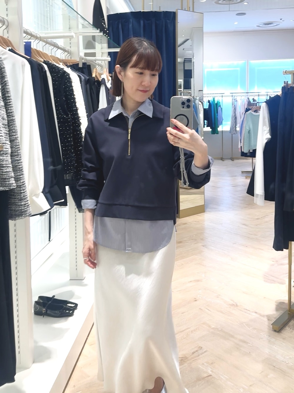 ホワイト系のスカート、ブルー系のスウェット、ブルー系のシャツ/ブラウスを着用したレディースの春コーディネートの3枚目の写真