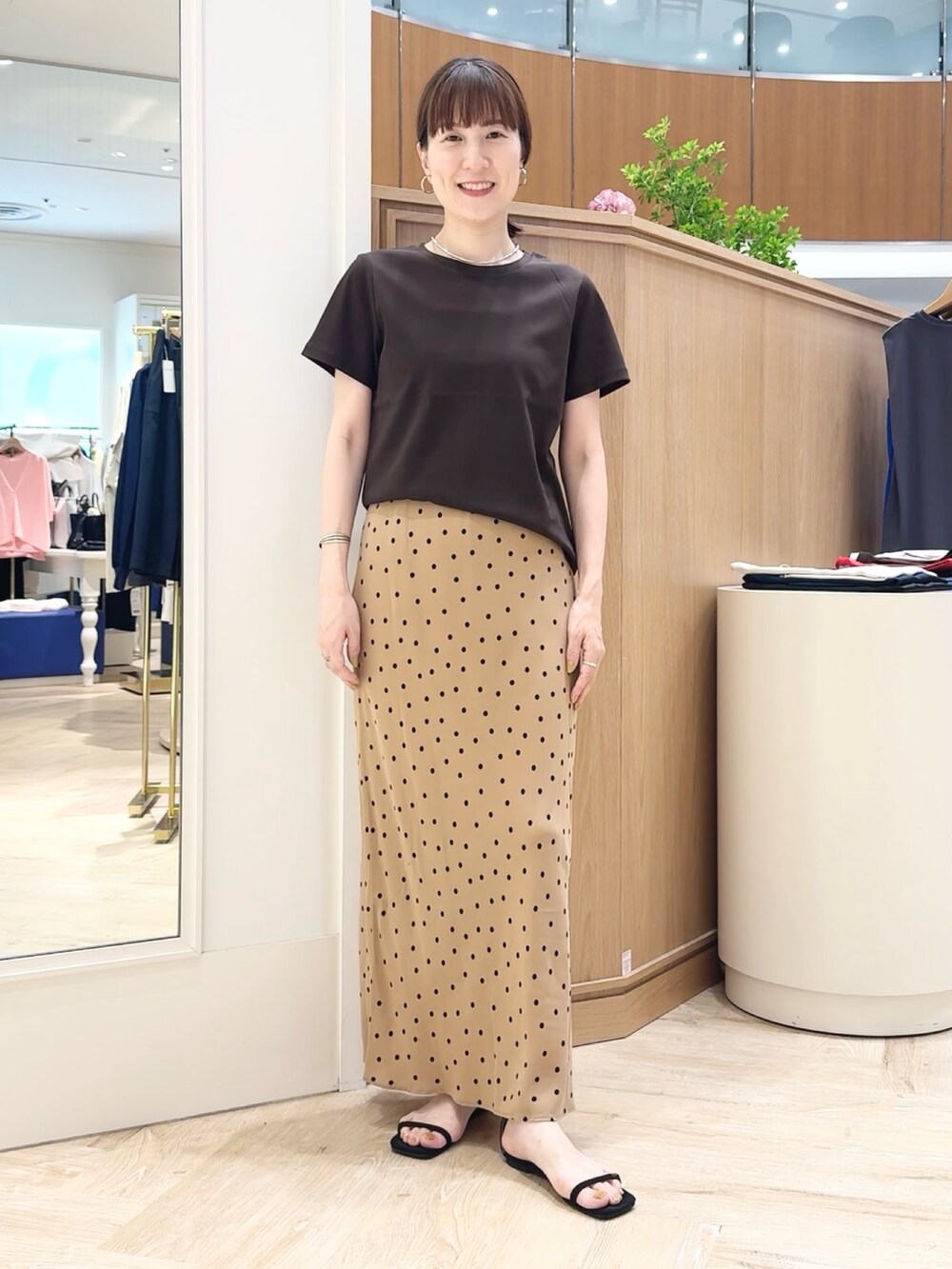 ブラウン系のスカート、ブラウン系のTシャツ/カットソー、シルバー系のチョーカーを着用したレディースの夏コーディネートの6枚目の写真