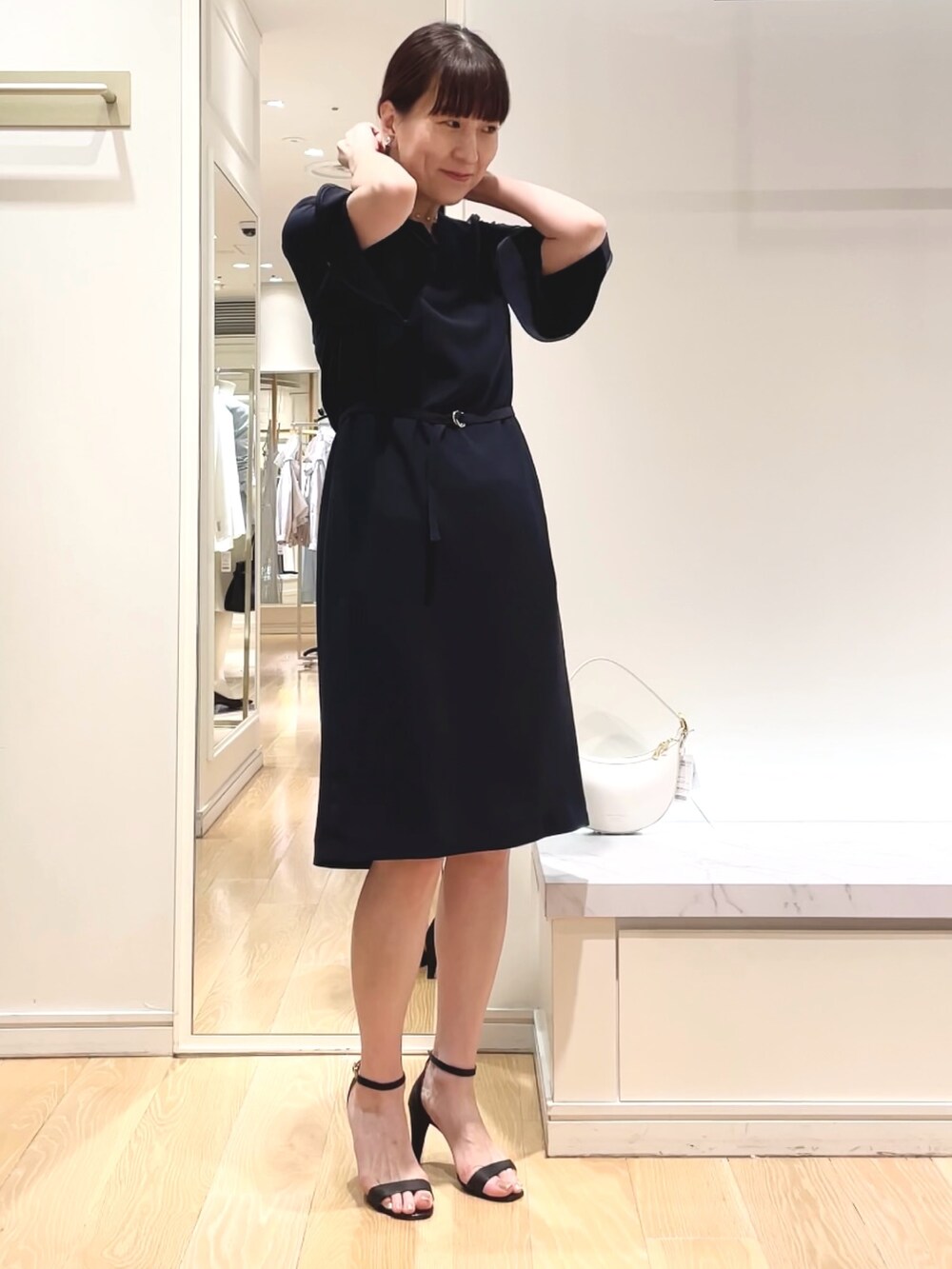 ブルー系のワンピース、ホワイト系のショルダーバッグ、シルバー系のイヤリングを着用したレディースの春コーディネートの6枚目の写真