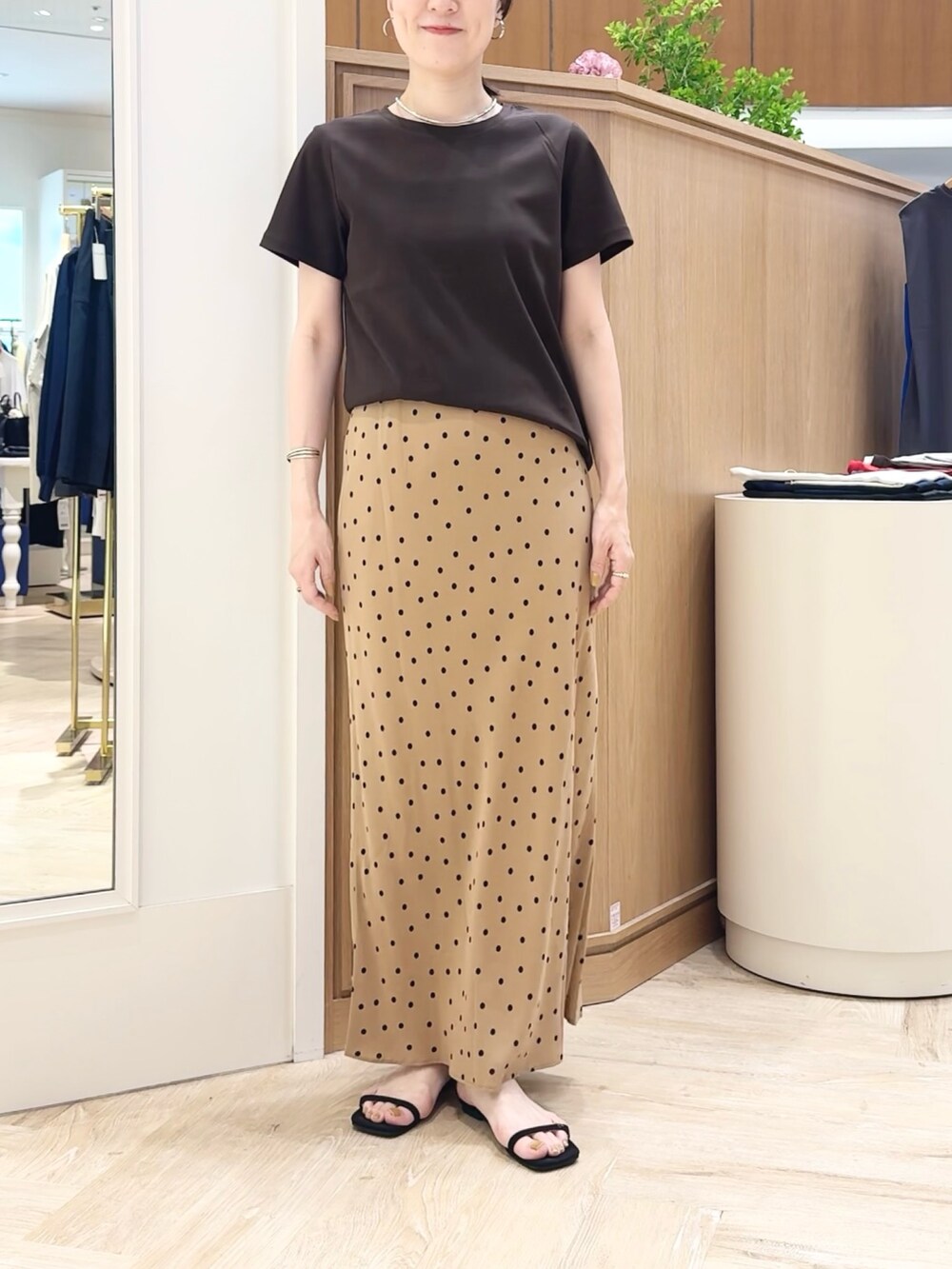 ブラウン系のスカート、ブラウン系のTシャツ/カットソー、シルバー系のチョーカーを着用したレディースの夏コーディネートの9枚目の写真