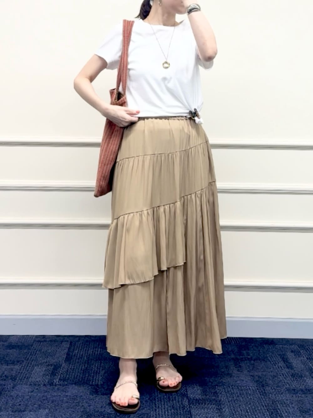 レッド系のトートバッグ、イエロー系のスカート、ホワイト系のTシャツ/カットソーを着用したレディースの夏コーディネートの6枚目の写真