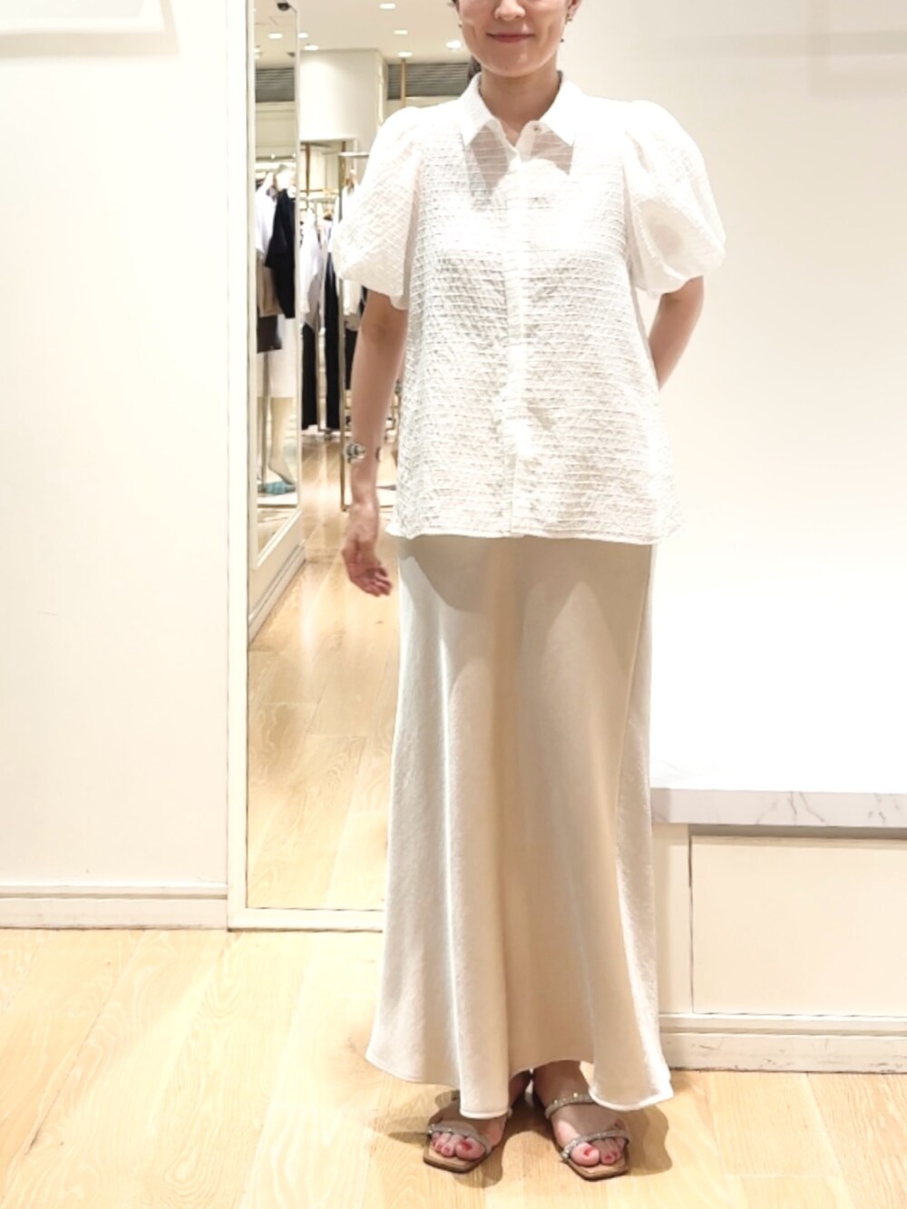 ベージュ系のスカート、ホワイト系のシャツ/ブラウス、ゴールド系のバレッタ/ヘアクリップを着用したレディースの夏コーディネートの4枚目の写真