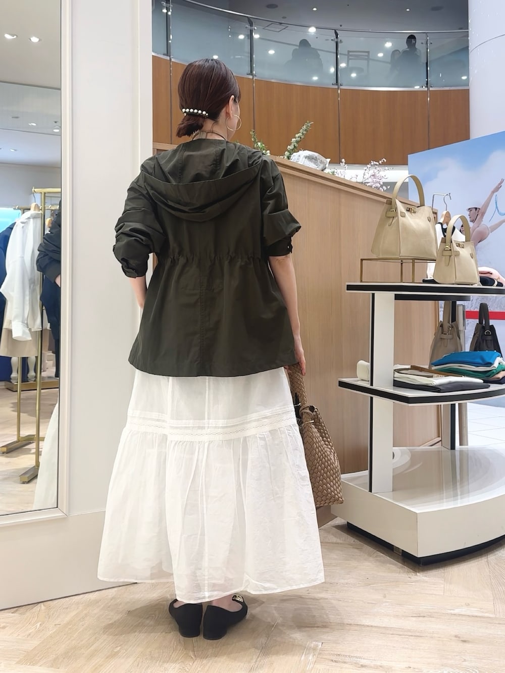 ブラウン系のショルダーバッグ、グレー系のブルゾン、ホワイト系のTシャツ/カットソーを着用したレディースの春コーディネートの4枚目の写真