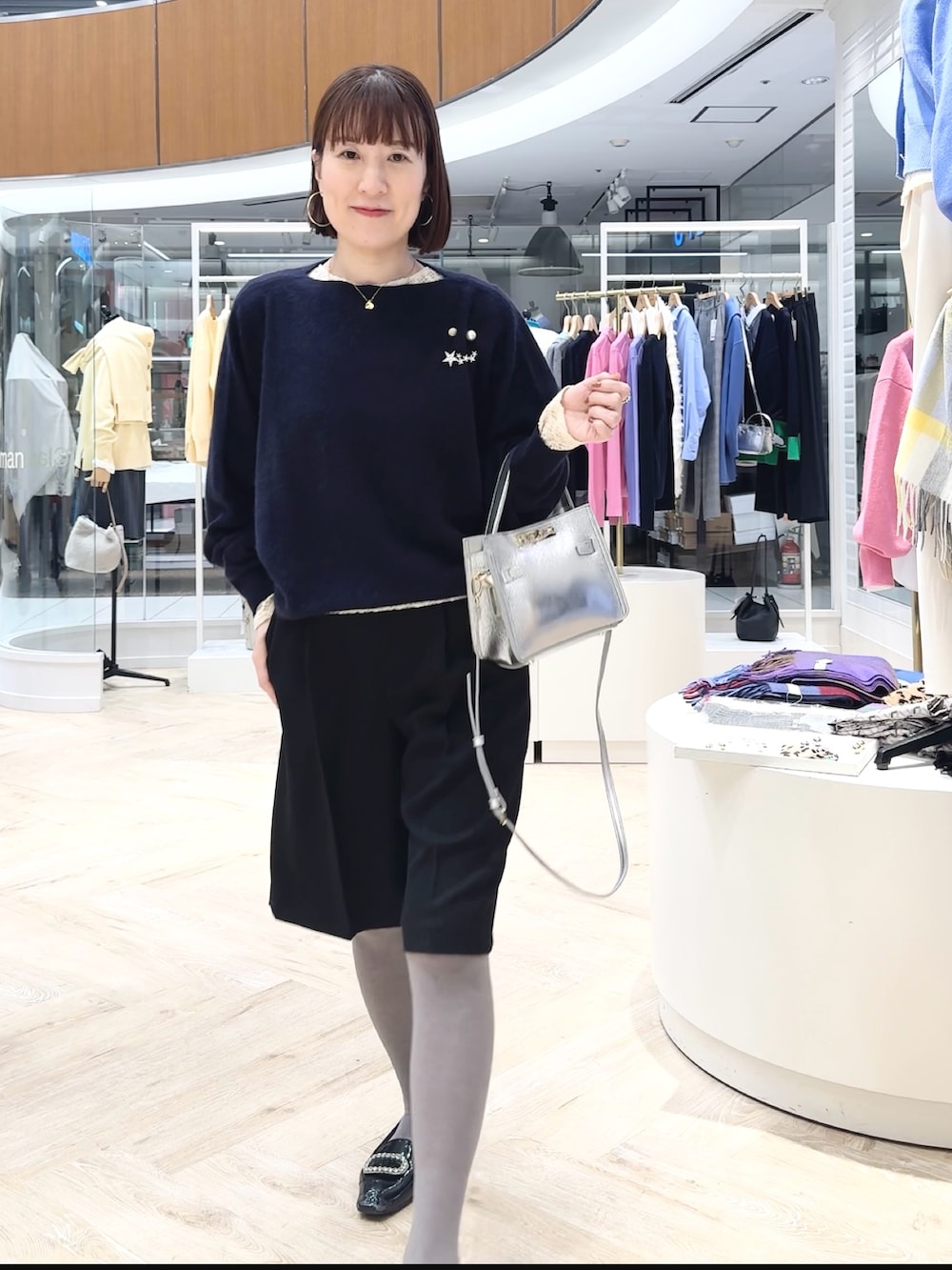 ブルー系のニット/セーター、ブラック系のその他パンツ、ホワイト系のカーディガン/ボレロを着用したレディースの冬コーディネートの2枚目の写真