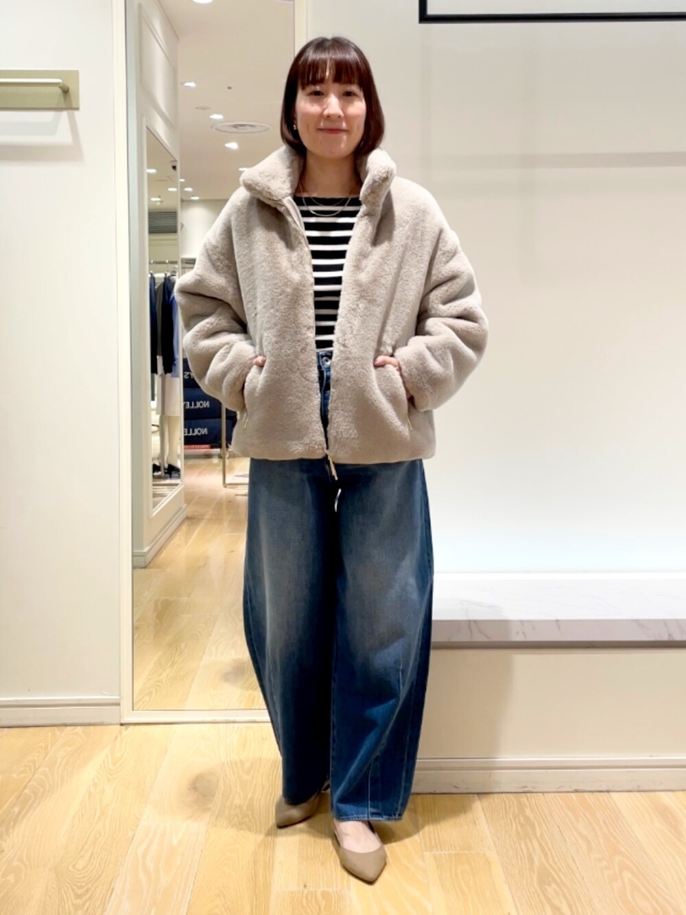 ブルー系のデニムパンツ、グレー系のブルゾン、ブラック系のニット/セーターを着用したレディースの秋コーディネートの5枚目の写真