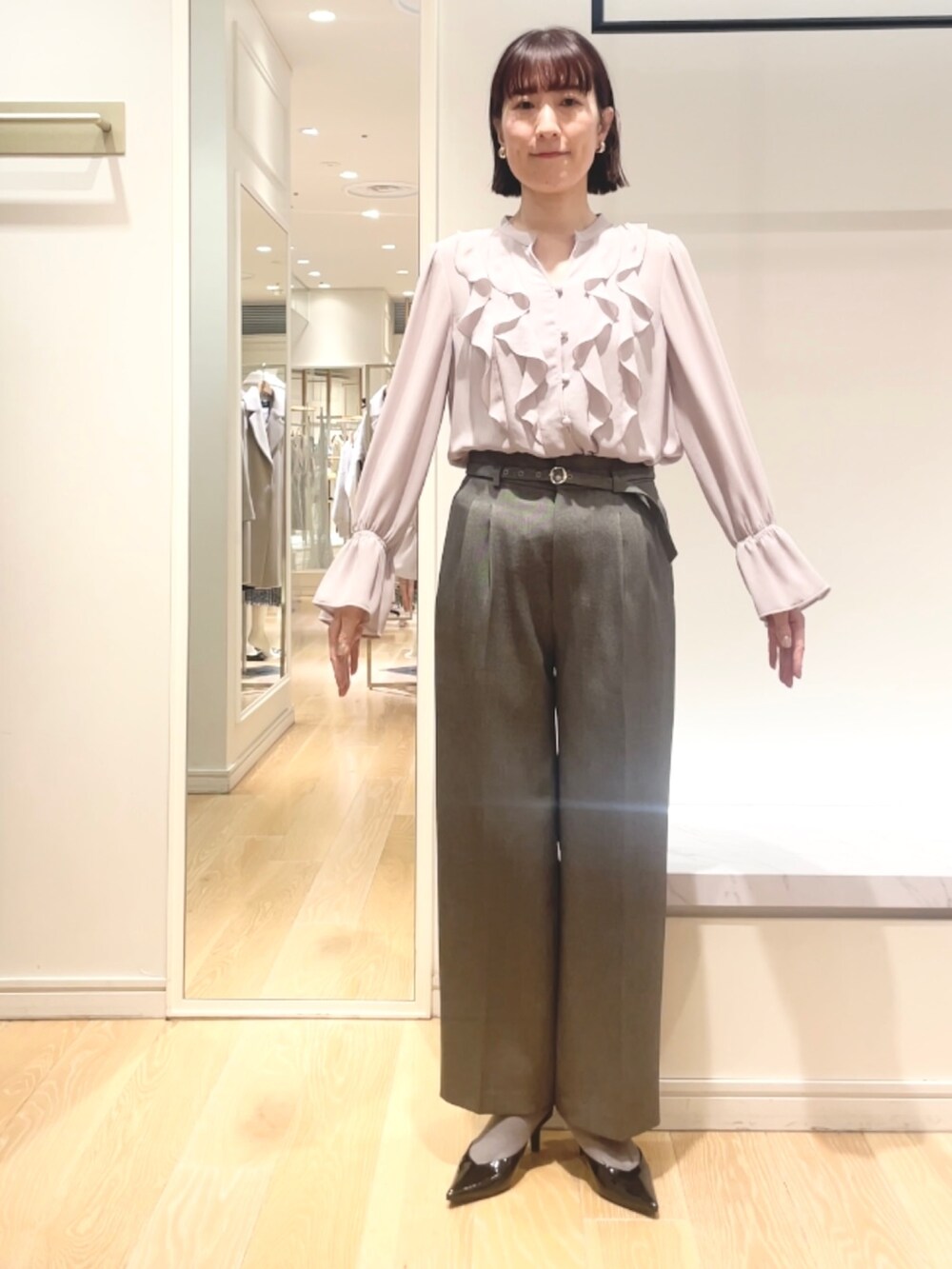 グレー系のその他パンツ、ピンク系のシャツ/ブラウス、ゴールド系のイヤリングを着用したレディースの冬コーディネートの8枚目の写真