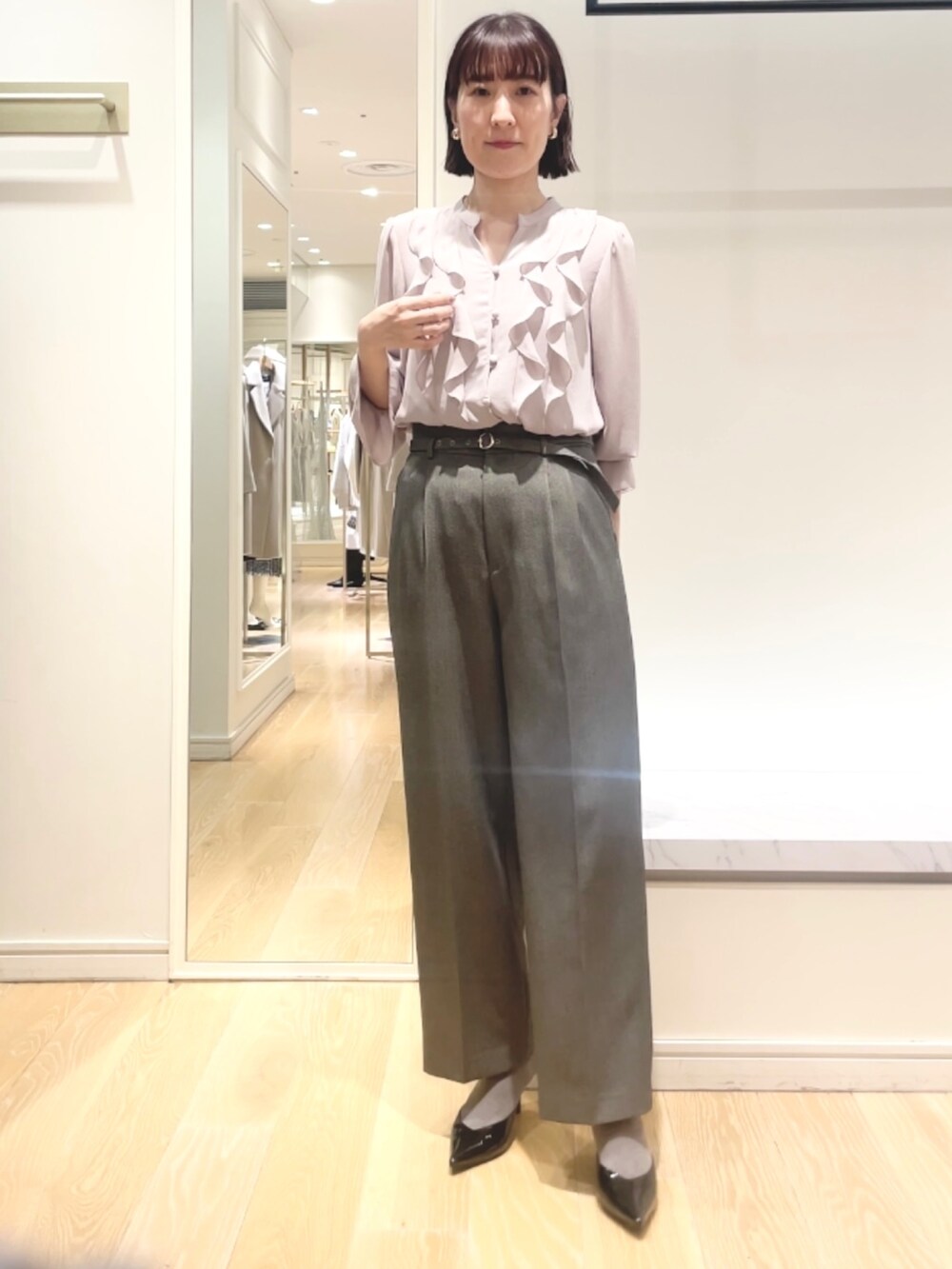 グレー系のその他パンツ、ピンク系のシャツ/ブラウス、ゴールド系のイヤリングを着用したレディースの冬コーディネートの6枚目の写真