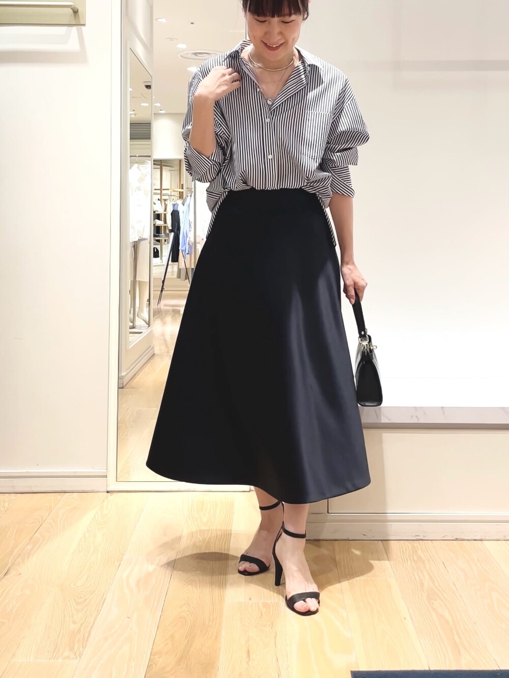 ホワイト系のシャツ/ブラウス、ブルー系のスカート、ブラック系のショルダーバッグを着用したレディースの春コーディネートの10枚目の写真