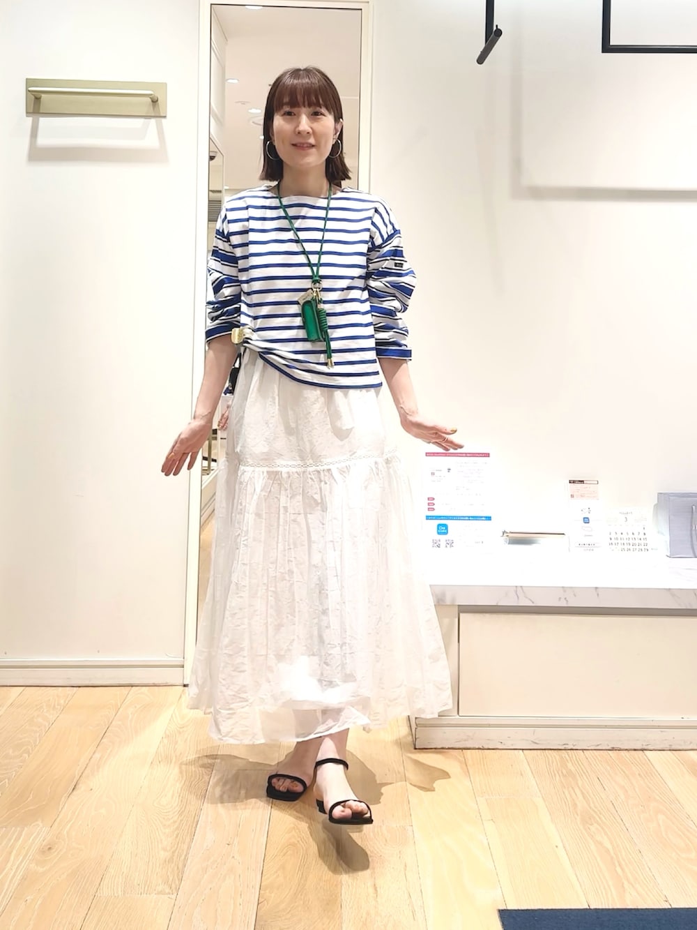 ブルー系のTシャツ/カットソー、グリーン系のチャーム、ベージュ系のヘアゴムを着用したレディースの春コーディネートの8枚目の写真