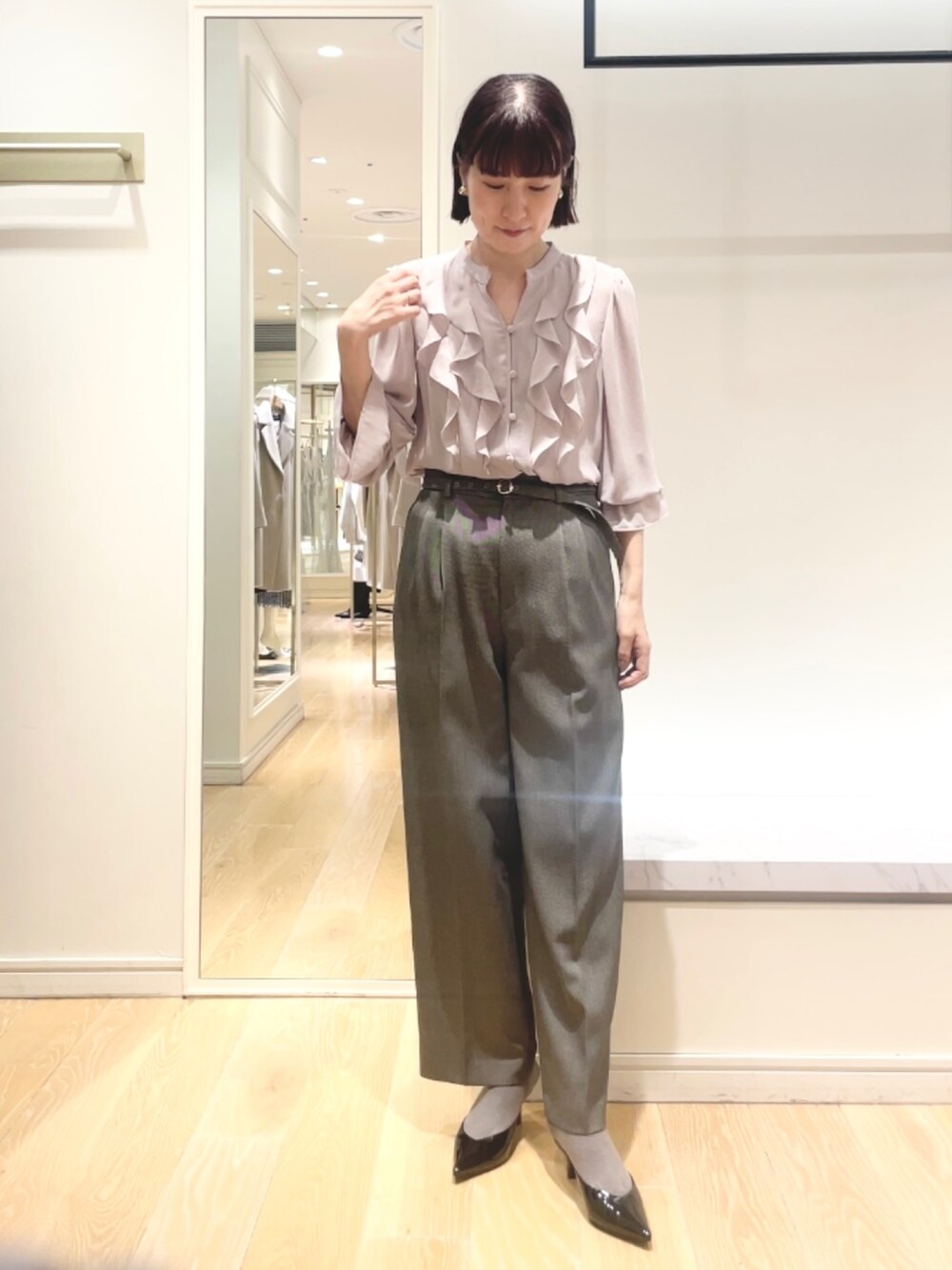 グレー系のその他パンツ、ピンク系のシャツ/ブラウス、ゴールド系のイヤリングを着用したレディースの冬コーディネートの4枚目の写真