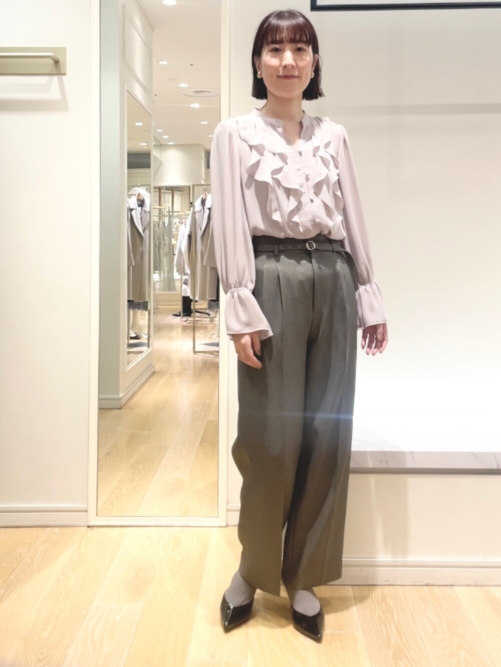 グレー系のその他パンツ、ピンク系のシャツ/ブラウス、ゴールド系のイヤリングを着用したレディースの冬コーディネートの7枚目の写真