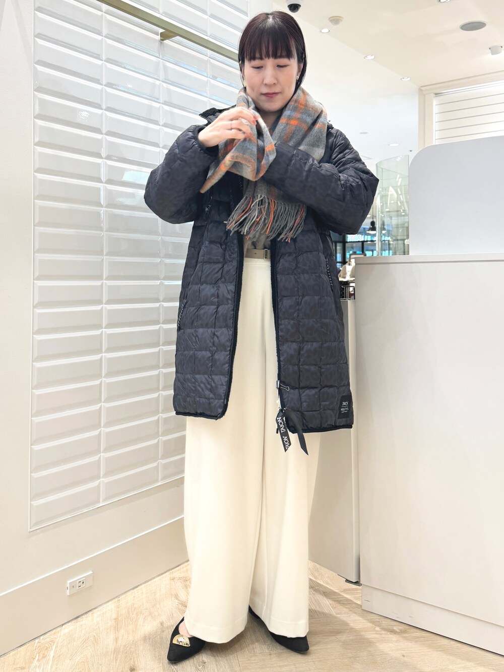 ホワイト系のその他パンツ、ベージュ系のトートバッグ、ブラック系のダウンジャケット/コートを着用したレディースの秋コーディネートの8枚目の写真