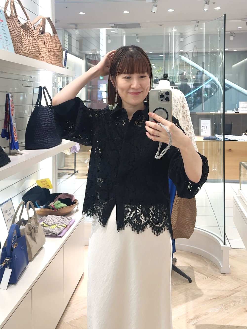 ホワイト系のスカート、ブラック系のシャツ/ブラウス、ブラック系のタンクトップを着用したレディースの春コーディネートの4枚目の写真