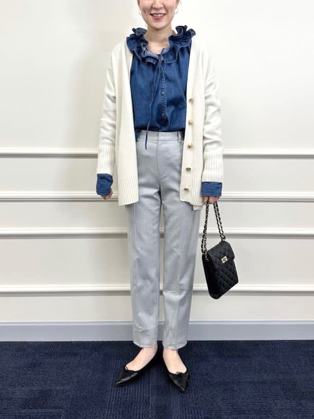 ブラック系のパンプス、グレー系のその他パンツ、ホワイト系のカーディガン/ボレロを着用したレディースの冬コーディネートの7枚目の写真
