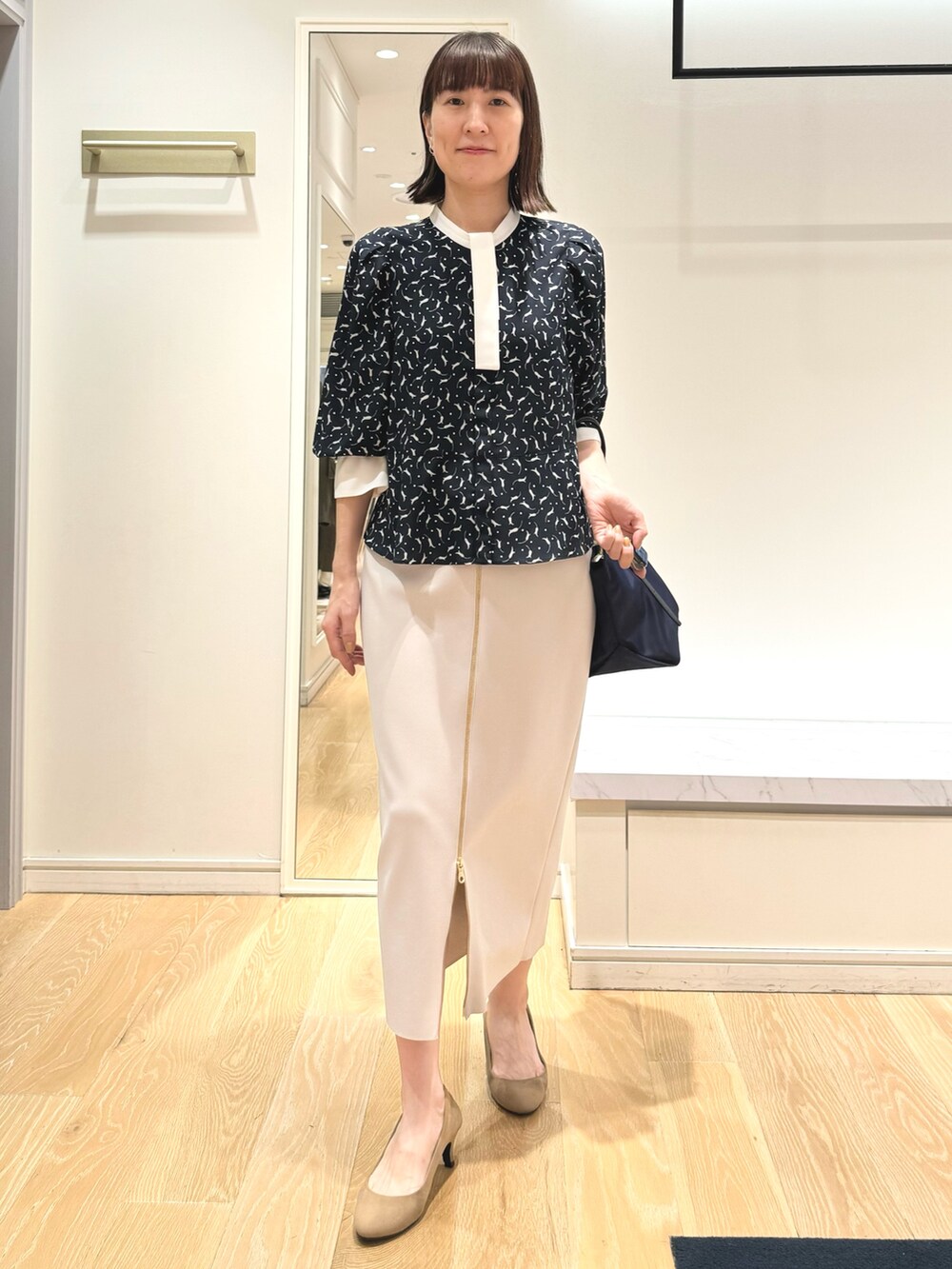 ベージュ系のスカート、ブルー系のトートバッグ、ブルー系のシャツ/ブラウスを着用したレディースの秋コーディネートの7枚目の写真