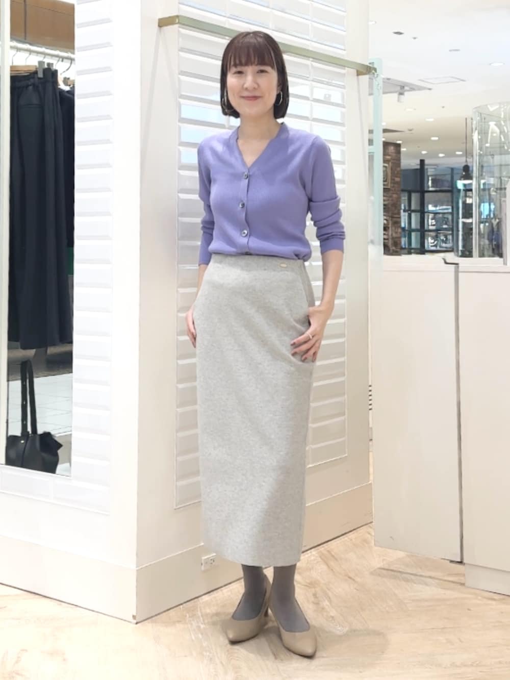 グレー系のスカート、パープル系のカーディガン/ボレロを着用したレディースの秋コーディネートの2枚目の写真