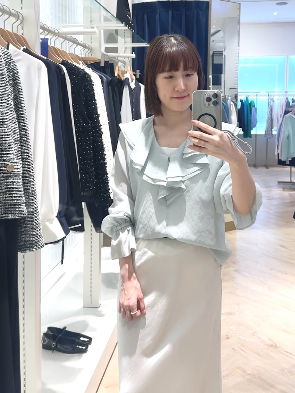 ホワイト系のスカート、グリーン系のシャツ/ブラウス、ホワイト系のタンクトップを着用したレディースの春コーディネートの6枚目の写真