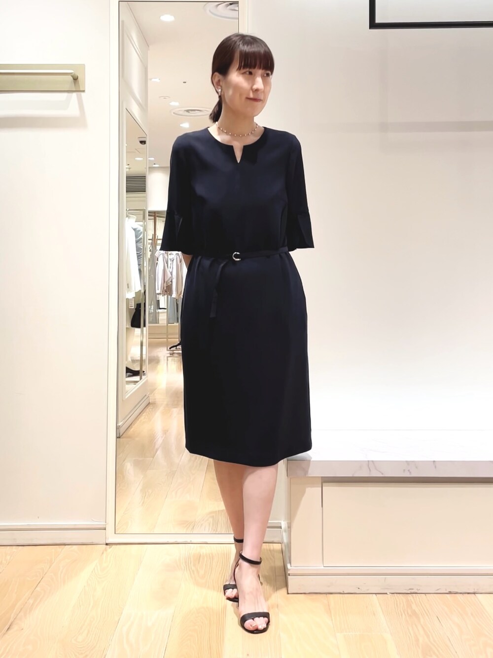 ブルー系のワンピース、ホワイト系のショルダーバッグ、シルバー系のイヤリングを着用したレディースの春コーディネートの2枚目の写真