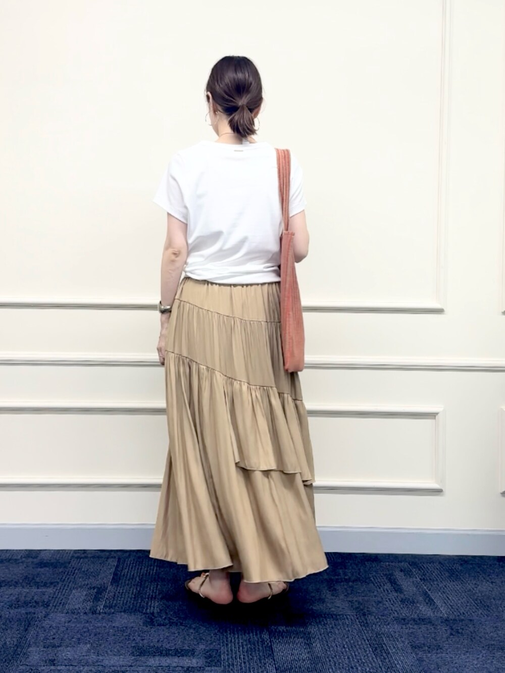 レッド系のトートバッグ、イエロー系のスカート、ホワイト系のTシャツ/カットソーを着用したレディースの夏コーディネートの4枚目の写真