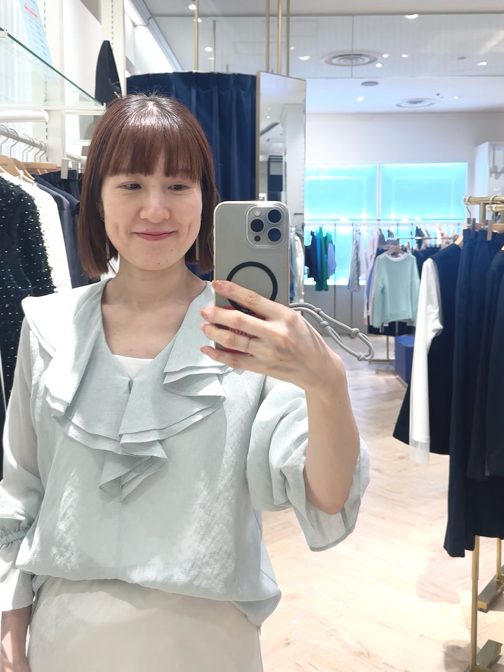 ホワイト系のスカート、グリーン系のシャツ/ブラウス、ホワイト系のタンクトップを着用したレディースの春コーディネートの5枚目の写真