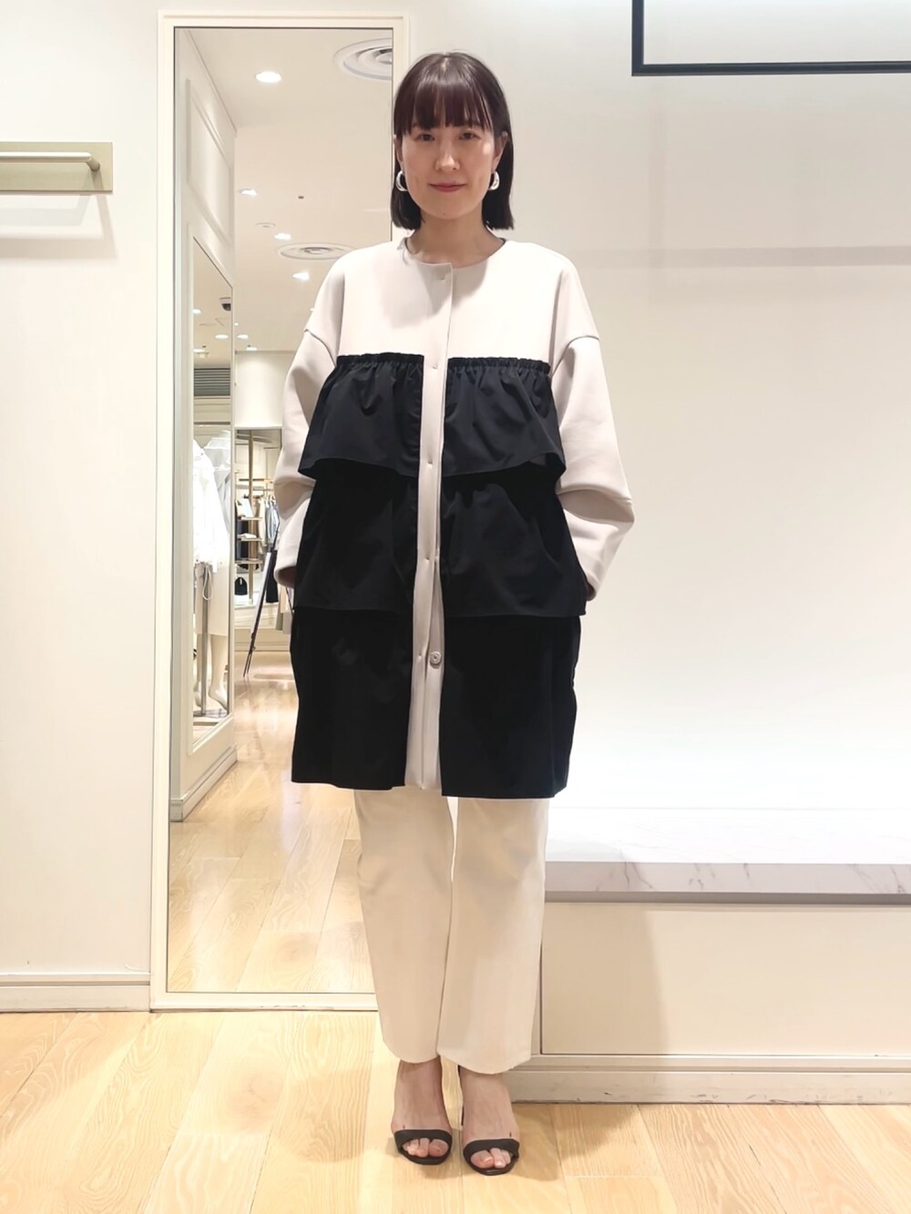 ベージュ系のその他アウター、ブラック系のショルダーバッグを着用したレディースの春コーディネートの3枚目の写真